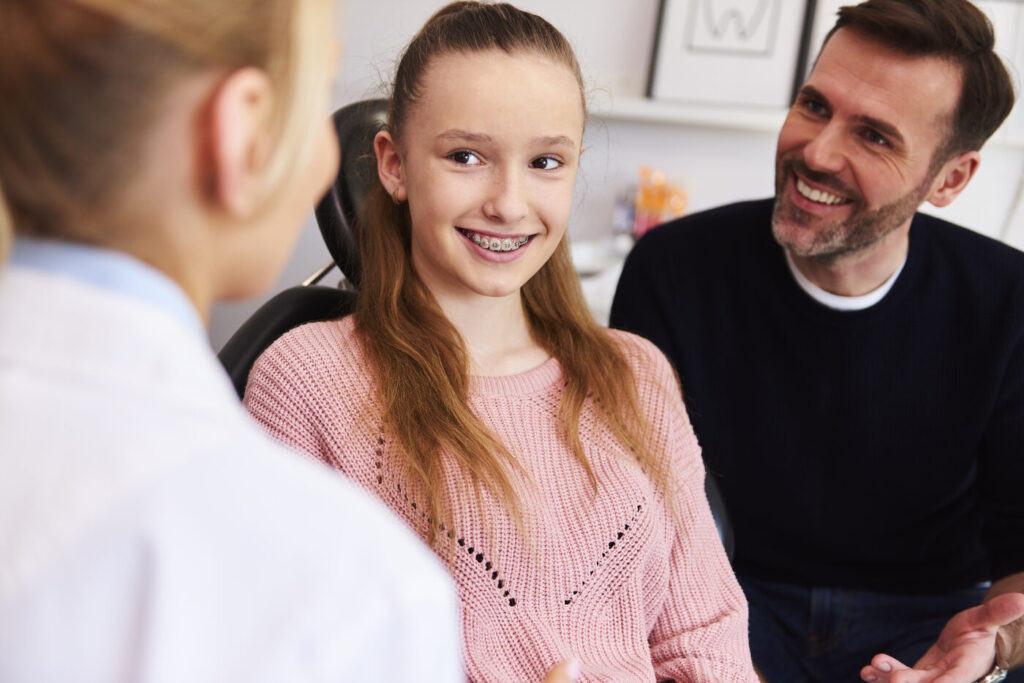 Girl with braces and her father at a first orthodontic checkup in Lake Forest, IL